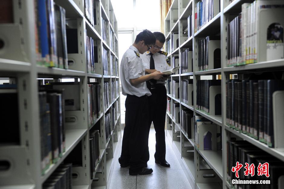 5月8日，武漢輕工大學(xué)保安吳濤與江力在圖書館交流學(xué)習(xí)。中新社發(fā) 張暢 攝