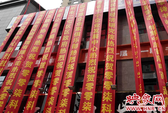 路邊一棟樓上懸掛著二三十條紅色條幅，全部是祝賀一家公司開業(yè)的。