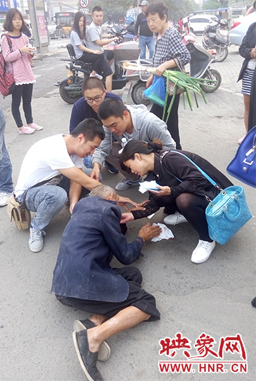 一些愛(ài)心市民在撥打了110和120后，上前給老人擦臉上的血跡。