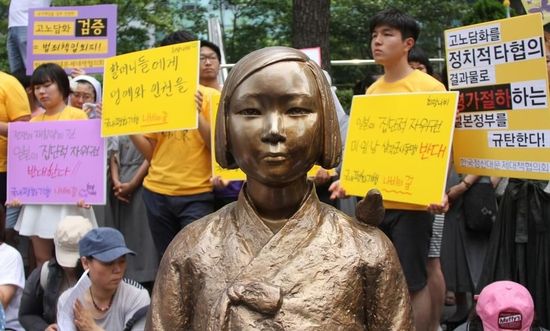 7月2日，在韓國(guó)首爾的日本駐韓國(guó)大使館前，民眾在慰安婦少女像旁手持標(biāo)語(yǔ)參加抗議活動(dòng)。