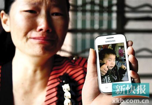 男童的舅媽拿著小益的照片,悲痛欲絕。 新快報記者 畢志毅 攝