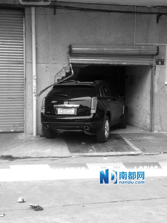　昨日，凱迪拉克撞人后停在一倉(cāng)庫(kù)門(mén)口，車(chē)后有一攤血跡。 南都記者陳杰生攝