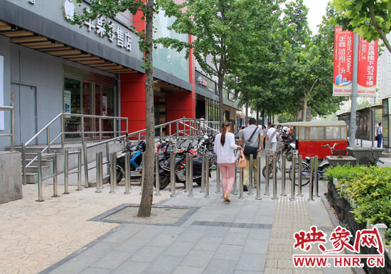 圖中道路左側(cè)的無障礙通道被鋼管隔離,右側(cè)的盲道也被侵占。 圖中道路左側(cè)的無障礙通道被鋼管隔離,右側(cè)的盲道也被侵占。