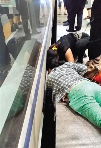 一女子趴在站臺(tái)上，救跌入列車和站臺(tái)間隙的男童。網(wǎng)友璀璨的星月夜 攝