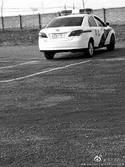 一輛車牌號 為“ 陜DD173”的制式警車停在一個劃著白線的場地上，車身標有“司法”字樣