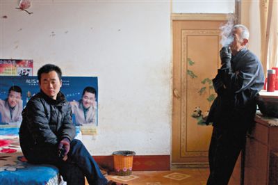 父親抽煙，兒子不語。逃跑的越南新娘，給袁迎賓父子帶來的是失落。新京報(bào)記者 周崗峰 攝
