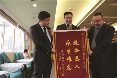 張乃余(中)和兩位救人的同伴一塊領(lǐng)獎。