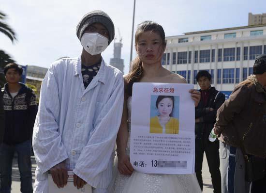 昆明火車站廣場上，24歲的黃習(xí)菊身穿潔白的婚紗，帶著身患白血病的弟弟征婚。