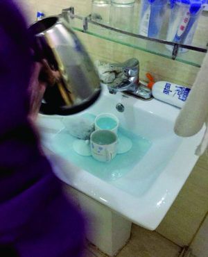 酒店服務(wù)員用潔廁液刷燒水壺和茶杯。