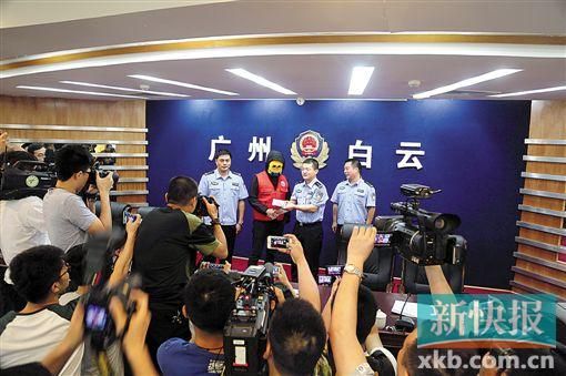 因舉報涉毒案件線索而獲獎的“快遞小哥”戴著面具領取獎金。