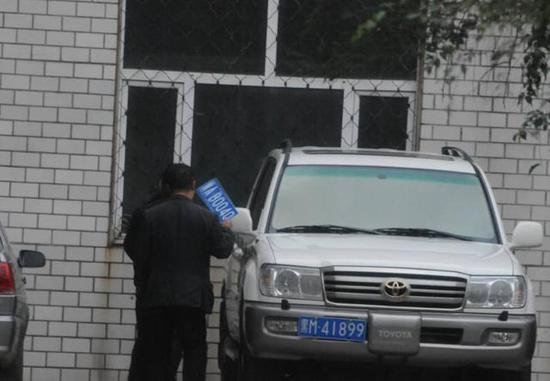 程父與程的“司機(jī)”在居住小區(qū)內(nèi)將黑AB0040車牌更換為黑M41899車牌，倆車牌號(hào)均為空號(hào)