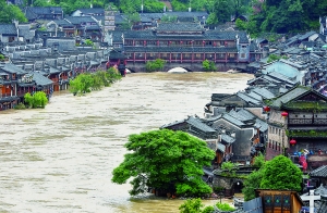 7月16日,沱江兩邊的商鋪和遠(yuǎn)處的虹橋仍淹沒在洪水中。 新華社發(fā)