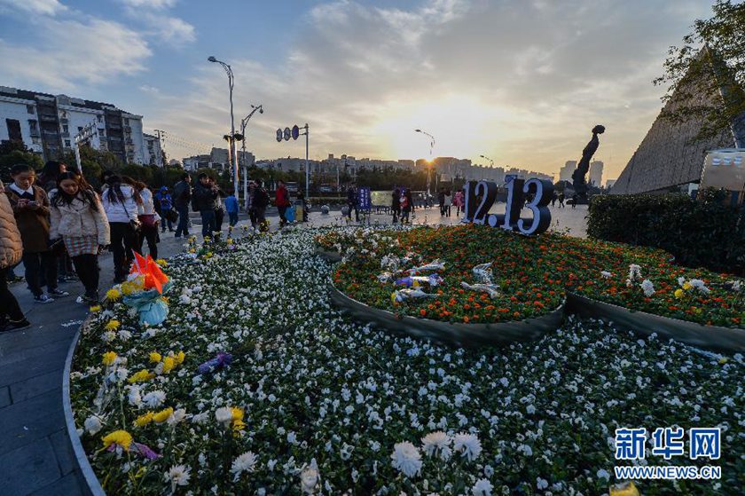 12月14日,觀眾在侵華日軍南京大屠殺遇難同胞紀念館前的“12·13”花壇上擺放鮮花祭奠遇難同胞。新華社記者 沈鵬 攝