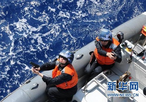 　3月28日，十余名臨檢拿捕隊員乘小艇駛至模擬可疑商船下方水面。