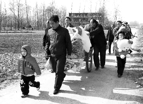 姐（左一）弟（右一護士懷中男嬰）返鄉(xiāng)，愛心捐贈滿滿一架子車。