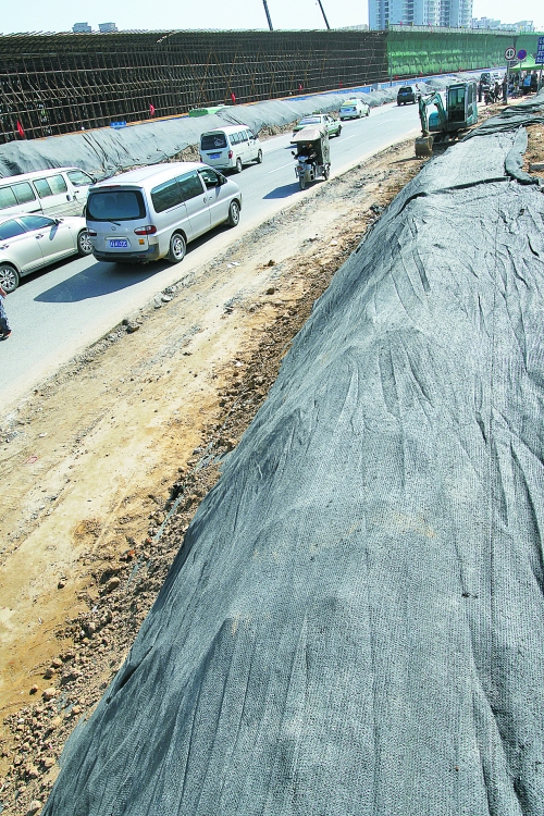 豐樂路與北三環(huán)交叉口，修路的土被歸置得整整齊齊，并用黑網(wǎng)覆蓋，既保暢通又避免了揚(yáng)塵。
