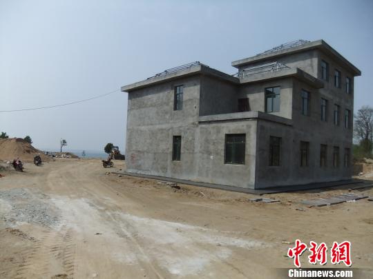 鴨河水庫(kù)庫(kù)區(qū)邊的新建別墅，一面墻上寫(xiě)著“拆”，另一邊在加緊施工。吳揚(yáng)　攝